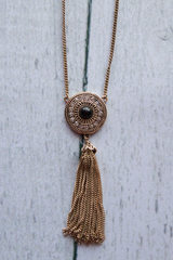 Gold and black pendant with tassel